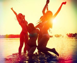 Beach Party. Teenage girls having fun in water. Group of happy y