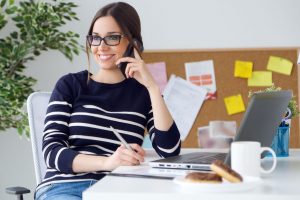 Confident Young Woman Working In Her Office With Mobile Phone.